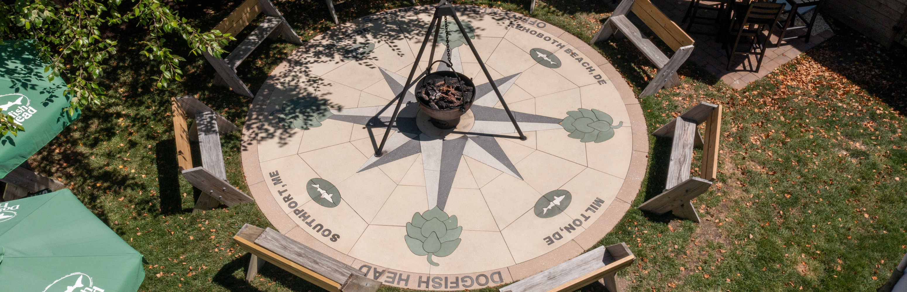 Large compass in the ground made out of pavers around the firepit at the Dogfish INN