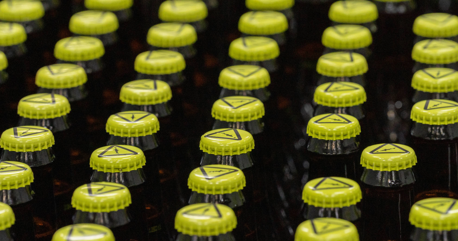 A cluster of bright yellow/neon green Dogfish Head Caution Caps beer caps