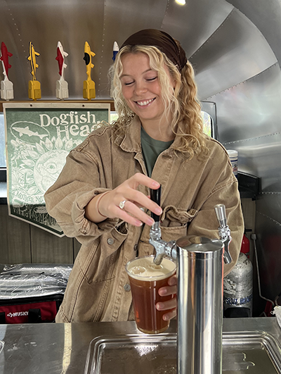 A Dogfish Head coworker pouring a beer in the Airstream at 2023 Punkin Ale Fest