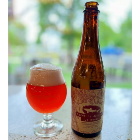 Dogfish Head beer Biere de Coupage: Le Rouge that is a hazy, pinkish hue with a rosy glow in a tulip glass next to a tall, brown bottle