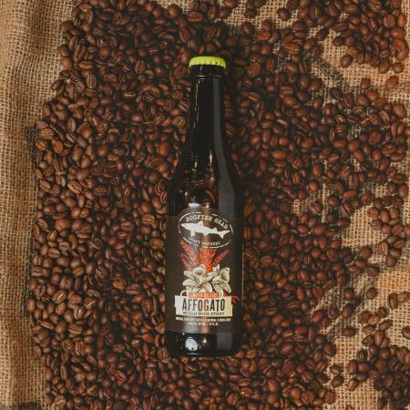 A bottle of Affogato World Wide Stout on a bed of coffee beans