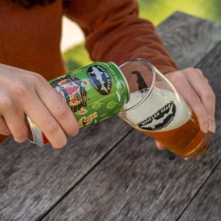 Dogfish Head Covered in Nuggs six-pack alongside a 12 oz. can with artwork from Methane Studios as the can art