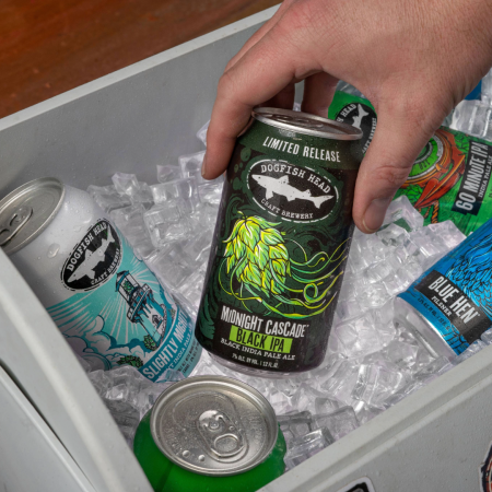 A can of Dogfish Head Midnight Cascade in a cooler being pulled out by a hand