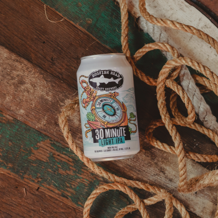 12 oz can of Dogfish Head 30 Minute Light IPA on a wooden surface with a nautical rope laying behind it