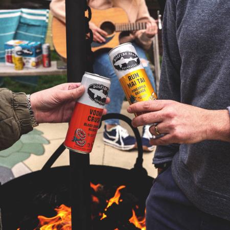 Dogfish Head Ready-To-Drink Cocktails toasting over a firepit during fall and autumn