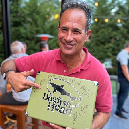 Sam Calagione of Dogfish Head holding a signed record player at Sam on the Shore 2023