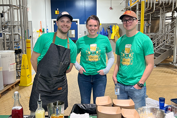 3 Dogfsih Head coworkers standing behind a tasting table.